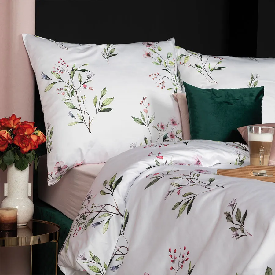 Elegancka pościel z pastelowymi kwiatami na białym tle.