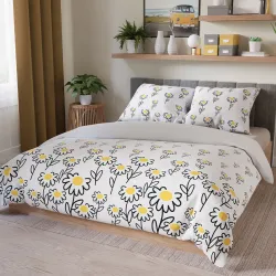 Stylowa pościel w biało-żółtej kolorystyce na łóżku.