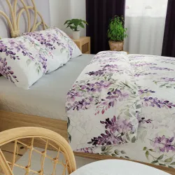 Przytulna sypialnia z pościelą w kwiatowy wzór w odcieniach fioletu.