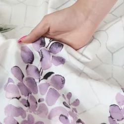 Biała pościel z fioletowymi kwiatami w stylowej sypialni.