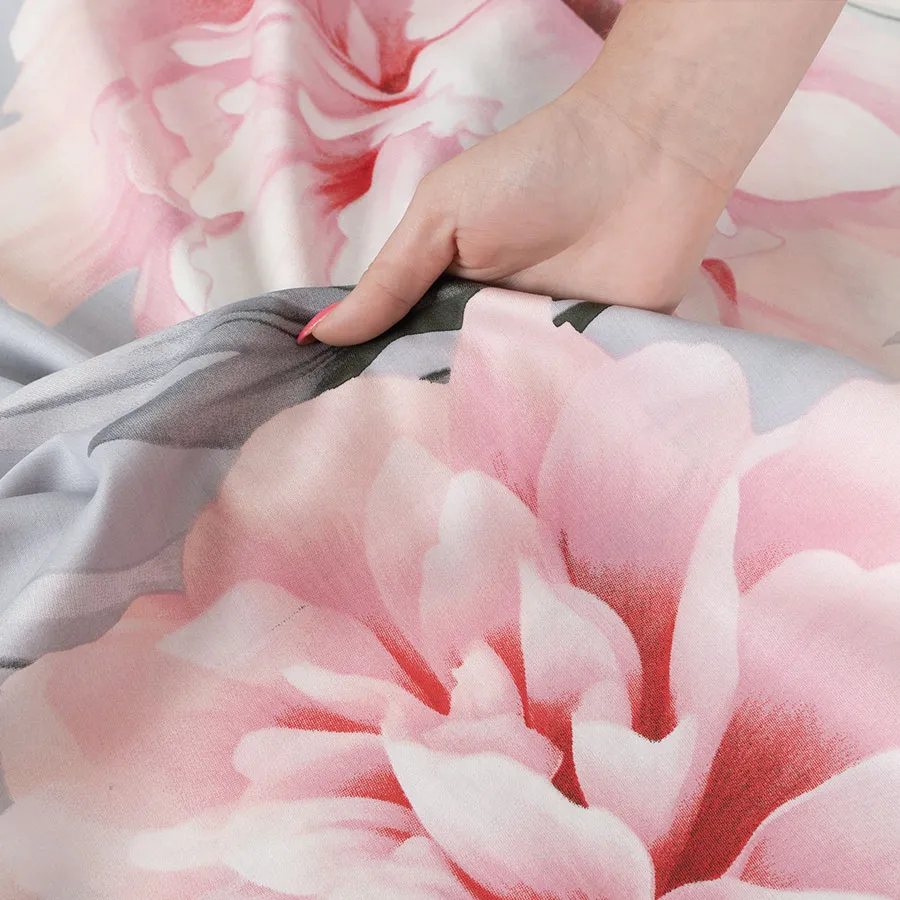 Detale pościeli MARIGOLD – różowe piwonie na subtelnym szarym tle.