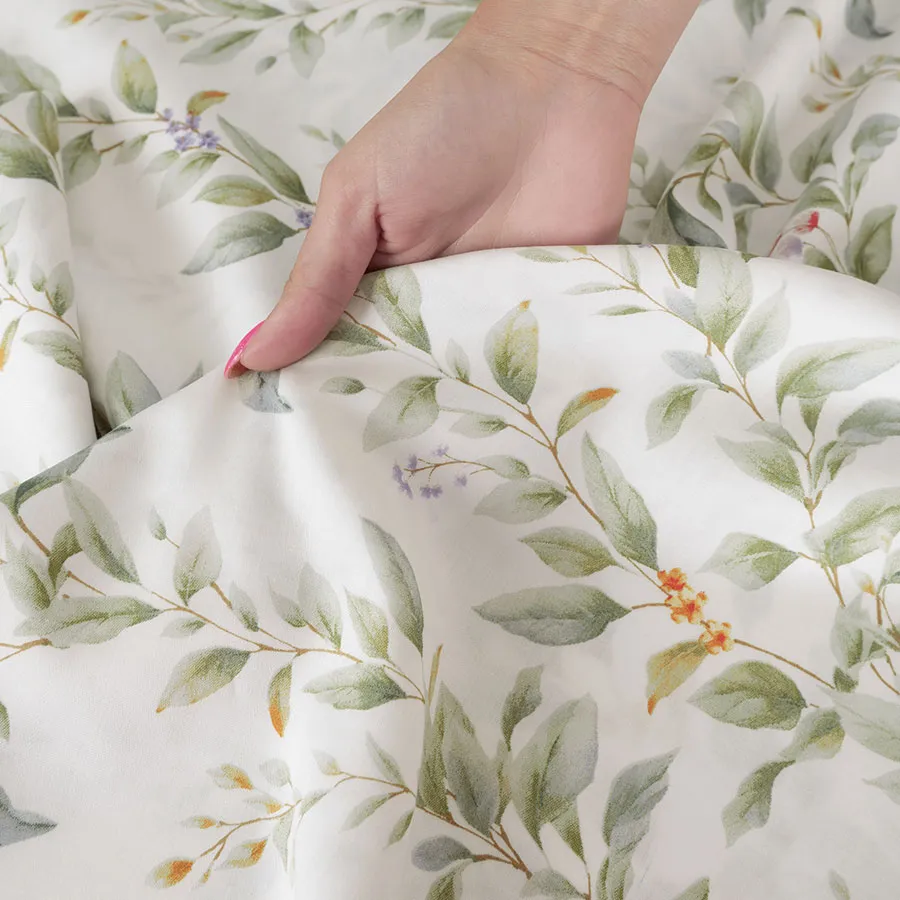Zbliżenie na detale pościeli RIMA – pastelowe liście i gałązki.
