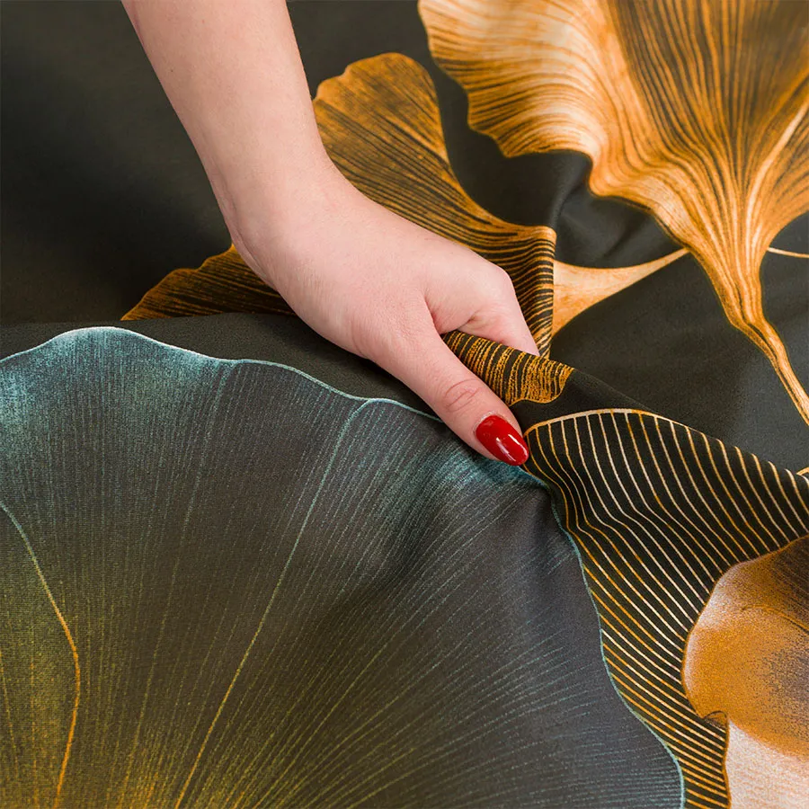 Zbliżenie na wzór pościeli MARISEL – złociste liście miłorzębu na ciemnym tle.